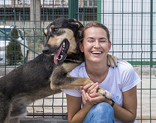 smiley woman playing shelter with dog waiting be adopted