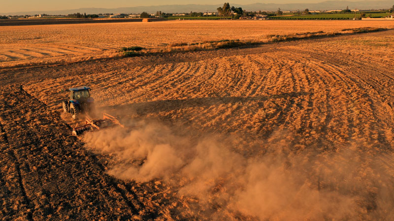 photo: a tractor on a brown dusty field