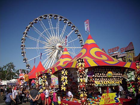 A giant ferris wheel looms over midway prize games